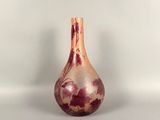 purple and white vase sitting on a white surface with a white background