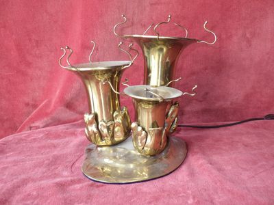 three brass vases that are sitting on a pink cloth