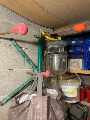 un sac rempli d'objets suspendu à une étagère dans un garage