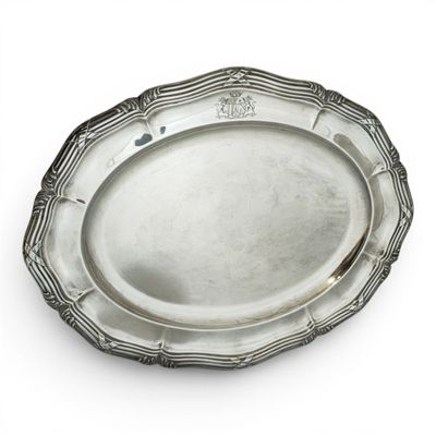an oval silver plate with a decorative design on the rim