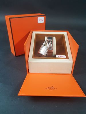 une boîte orange contenant une montre, posée sur une table