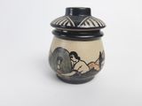 a small vase with a painting on it on a white surface
