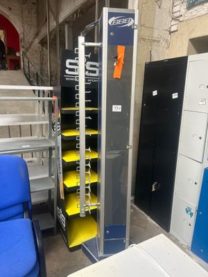 une chaise bleue posée à côté d'un support métallique muni de plateaux jaunes