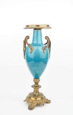 a blue vase that is sitting on a gold stand