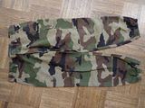 a pair of camouflage pants sitting on a wooden floor