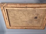 a close up of an old wooden frame hanging on a wall