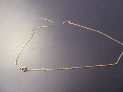 gold filled necklace with two interlinked circles on a black surface
