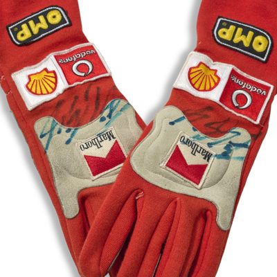 pair of red gloves with shell logos on them on a white background