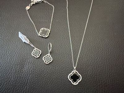 a close up of a necklace and earrings on a table