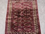 un tapis rouge et or posé sur un sol gris