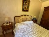 un lit recouvert d'un couvre-lit blanc et une table de chevet sur laquelle se trouve une lampe