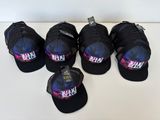six black hats with pink and blue designs on them sitting on a table