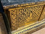 an old wooden chest with a black and gold design on it