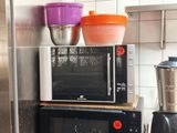 two microwaves sitting on top of each other in the kitchen
