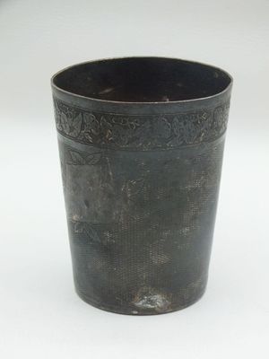 a black cup that is sitting on a white surface