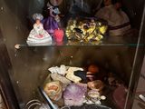 a display case with dolls and other items in it