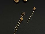 trois boucles d'oreilles en or et une paire de boucles d'oreilles posées sur un fond noir