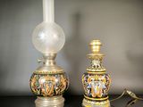 two vases sitting on a table with a lamp on it