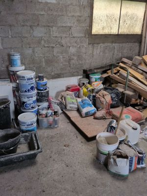 un tas de bois et de peinture par terre dans une pièce
