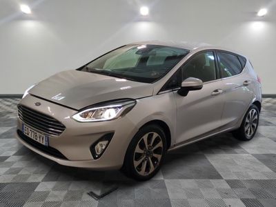 une Ford Fiesta argentée garée sur un sol en damier dans un garage