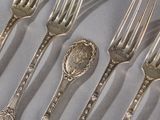 a lot of silver spoons and forks on a table