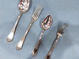five silver spoons and a fork on a table