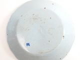 a white plate with a blue flower on it