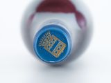a close up of a bottle of wine on a white surface