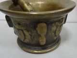 a metal mortar with a wooden spoon in it