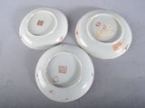 three white plates with designs on them are sitting on a table