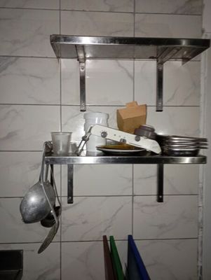 a shelf with a bunch of dishes and utensils on it