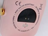 a close up of a pink watch on a white surface
