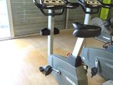 two stationary exercise bikes in a gym room with a sliding glass door