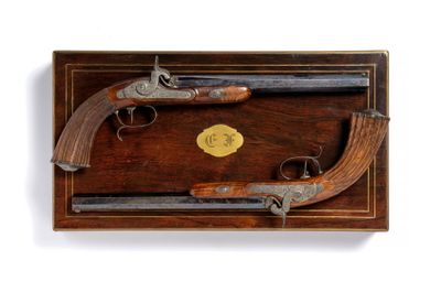 une vieille paire de pistolets dans un coffret en bois, sur fond blanc
