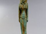 une statue égyptienne représentant une femme tenant un oiseau sur un socle