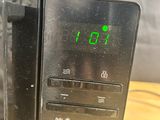 a microwave that has a digital clock on the side of it