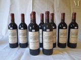 six bottles of wine are lined up on a table