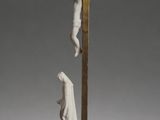 a statue of jesus on the cross with a person hanging from it