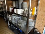beaucoup d'assiettes et de casseroles sur les étagères de la cuisine