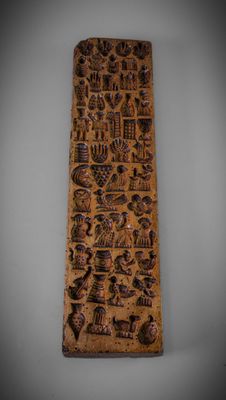 an old wooden plaque with a lot of different designs on it