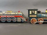 two toy trains sitting next to each other on a table