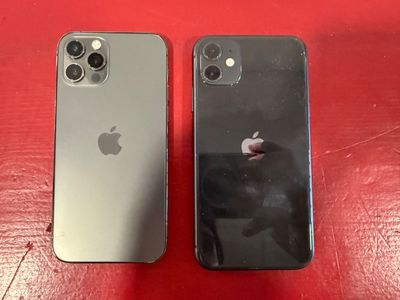 two iphones sitting side by side on a red table