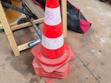 a red and white traffic cone sitting on the ground