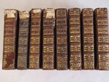 plusieurs vieux livres sont alignés sur une surface blanche