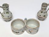 three cups and a jug sitting on a table