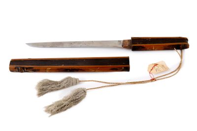 a knife that is sitting next to a piece of wood