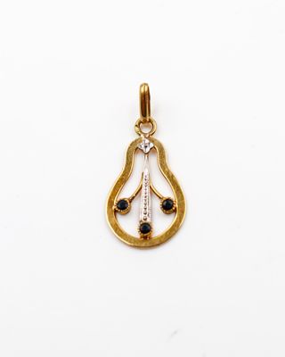 une photo d'un pendentif en or serti d'un diamant noir et blanc