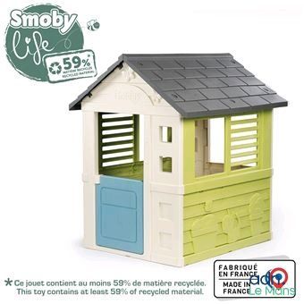 une maisonnette avec une porte bleue et un toit vert