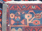 a close up of a blue and red rug with a picture of a man and a woman on it