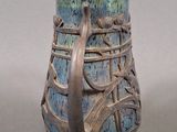 a blue vase with a bird on it sitting on a table